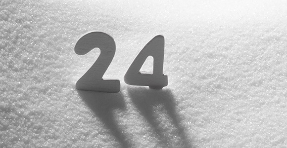 Die Zahl 24 in den Schnee gesteckt.